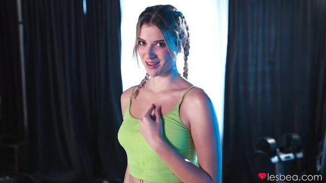 Blonde Isabella De Laa in green tank top smiles seductively