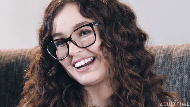 Leana Lovings smiles in glasses, curly hair in Adult Time interview