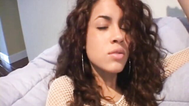 Hot ebony teen with curly hair in fishnet top, seductive eyes closed