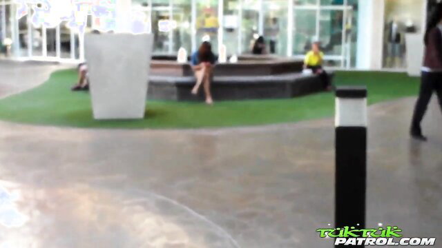 Thai amateur babe in short shorts sits legs spread on mall bench