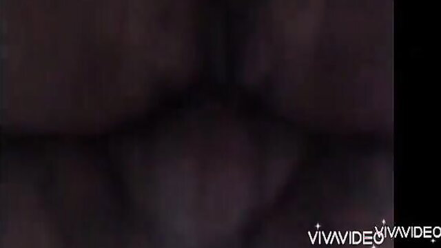 Blurry close-up of nude woman's big tits and body in dim light