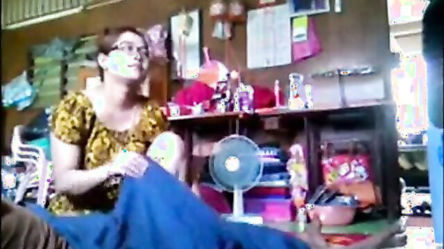 Asian mature woman in floral dress teases with legs spread on chair