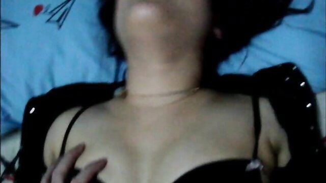 Thai girl in black lingerie lying back, teasing her big tits