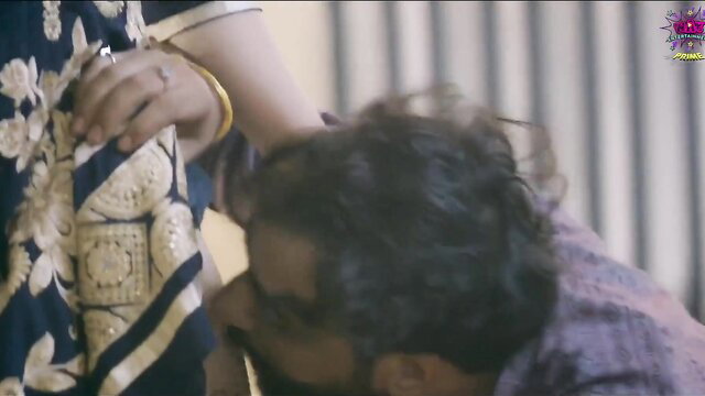 Indian woman in saree grabs man's head as he kisses her midriff closeup