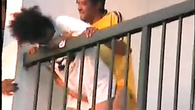Black guy lifts tiny black girlfriend over balcony railing for public bang