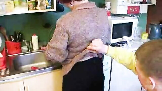 Boy lifts MILF mother-in-law's skirt for kitchen cunnilingus