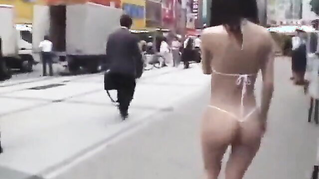 Japanese teen in glasses walks nearly nude in thong bikini on busy street