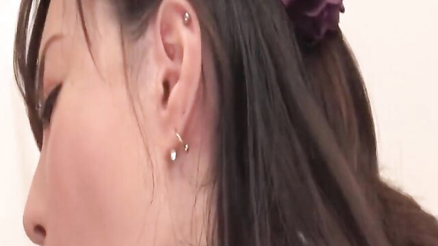 Hot Asian MILF closeup with earrings and purple hair flower