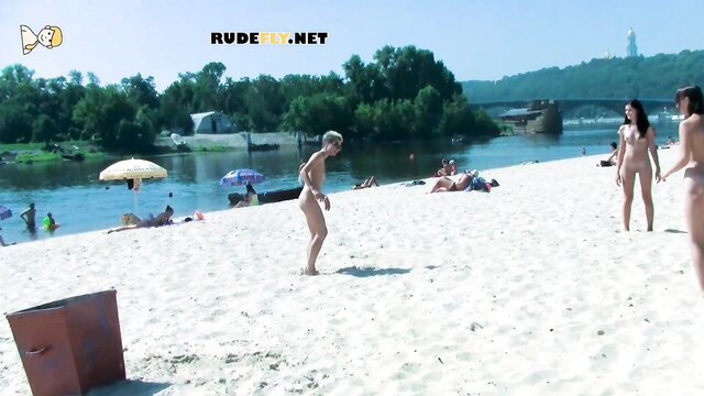 Nude tan-lined girls flaunting bodies on sunny beach with guy