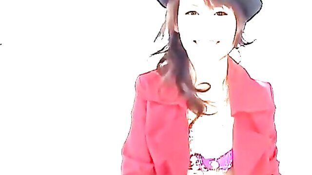 Naughty Japanese girl in pink coat and hat smiles seductively