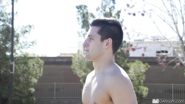 Handsome shirtless college guy profile in sunny outdoor public spot