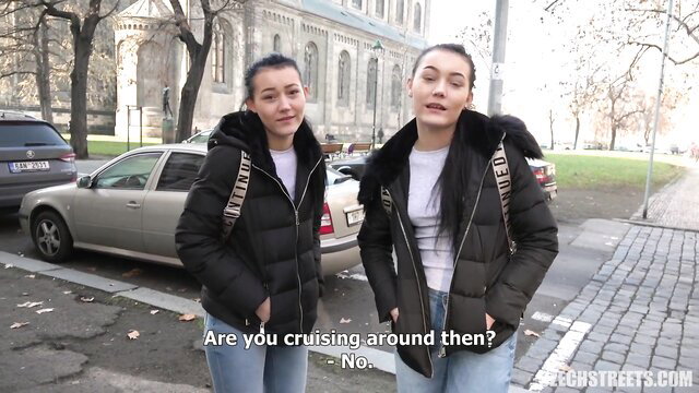 Young Czech twins in sexy jackets and jeans outdoors, teasing smiles