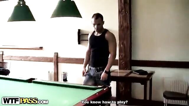 Muscular guy in tank top at pool table in wild cottage party