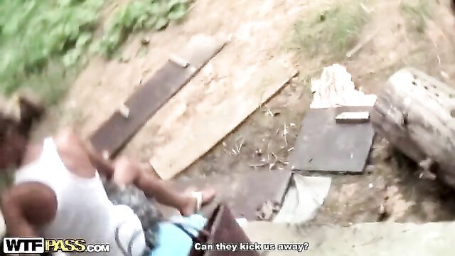 Skinny babe in white tank top grabbed by guy amid wood in outdoor public spot