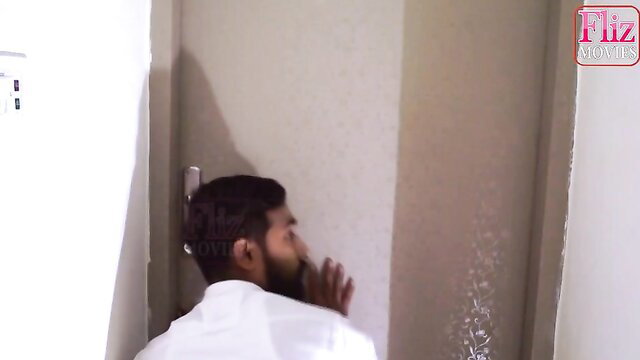Indian man in white shirt side profile against wall, Fliz Movies watermark