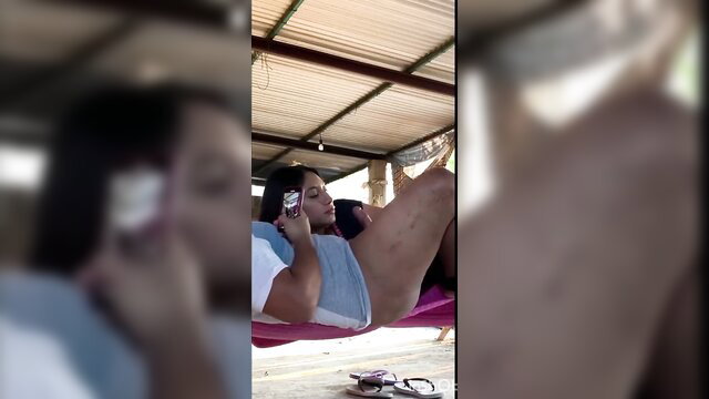 Hot Latina babe in hammock on phone, legs spread wide, upskirt tease