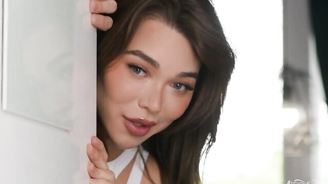 Hot brunette peeking seductively from door in tight white top