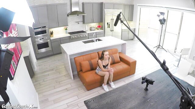 Naomi Blue on casting couch in tiny top and shorts, legs spread