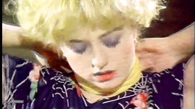 Blonde babe in sheer black dress with yellow scarf, intense closeup gaze