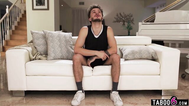 Spencer Scott's stepson lounging on couch in tank top and shorts