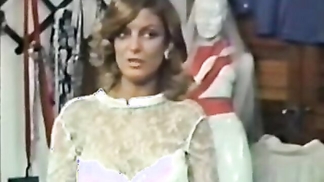 Vintage mature blonde in sheer lace top posing in adult store