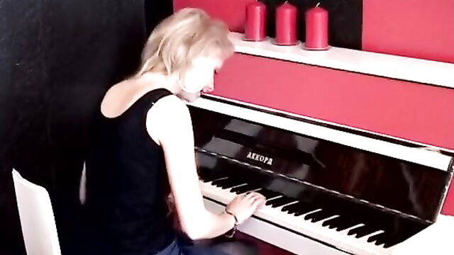 Blonde woman playing piano in tank top at home party