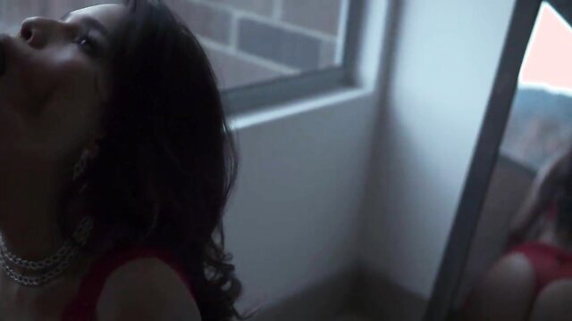 Asian beauty in red lingerie posing seductively by mirror