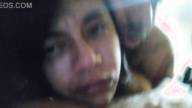 Blurry close-up of Asian woman held by tattooed man in intimate embrace