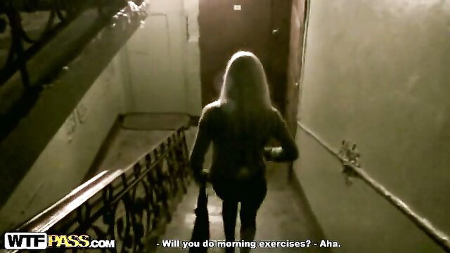 Blonde amateur walking away in dimly lit hallway, teasing morning exercises