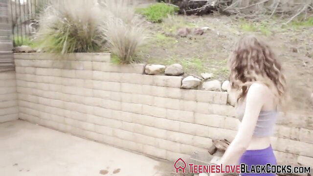 Petite curly blonde teen in crop top and shorts by pool wall