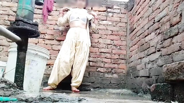 Young Indian teen in white salwar kameez posing sexy outdoors