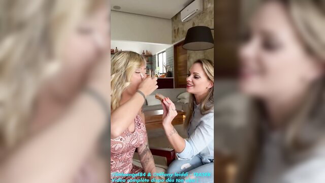 Two hot blondes feeding each other playfully in naughty lesbian tease