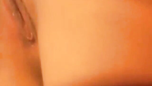 Busty black-haired MILF tenderly fingers her bald pussy closeup