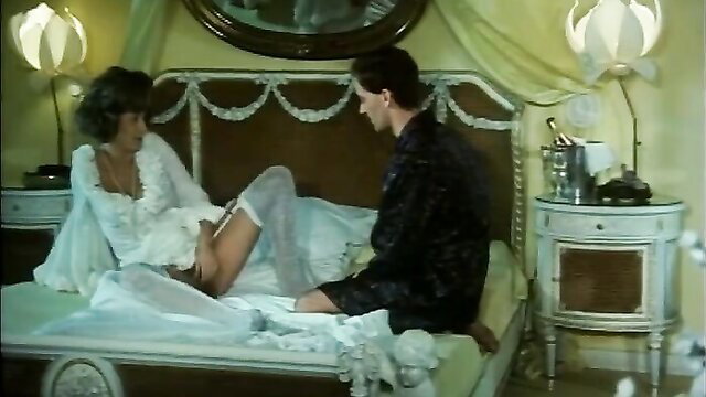 Josefine Mutzenbacher brunette in lingerie flashes stockings on bed with man