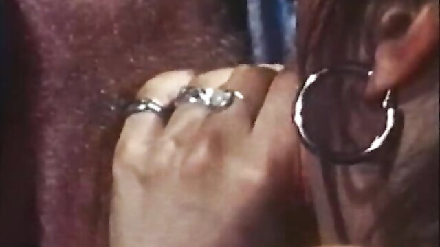 Closeup of woman's hand with rings and large hoop earring in classic XXX scene