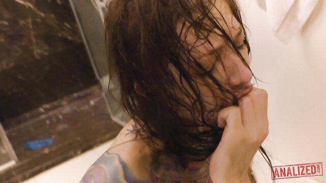 Kelsi Lynn wet-haired in intense anal training, gripping fist to mouth