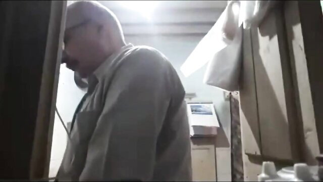 Bald Indian doctor in lab coat in dimly lit clinic MMS thumbnail