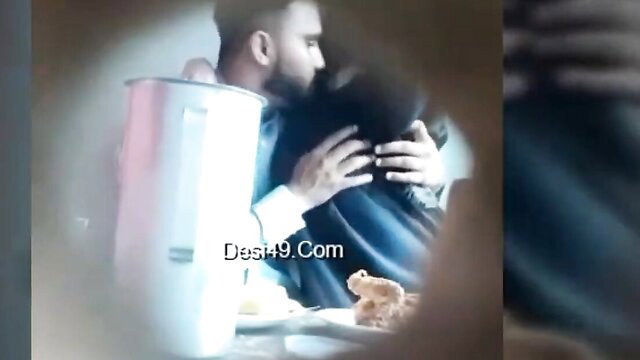 Indian couple embracing intimately in cafe on hidden cam