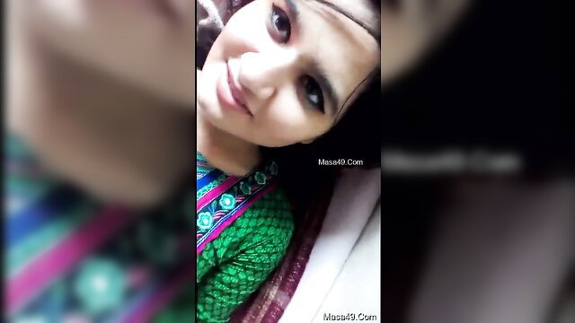 Pretty young Indian girl in green saree smiling selfie-style