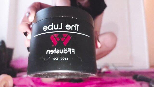 Amateur goth girl holds black lube jar, preps for giant dildo ass stretch