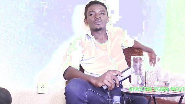 African man in yellow shirt sits casually holding glass, amateur style