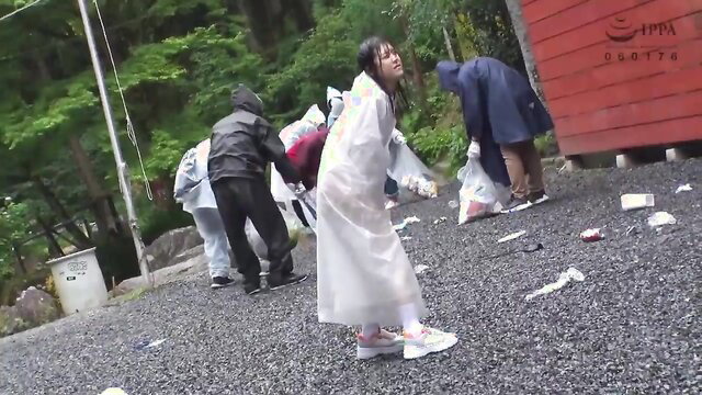 Asian women in raincoats cleaning outdoors in rain, sexy wet look