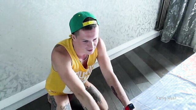 Oliver Strelly tattooed hunk kneeling in yellow tank top and cap