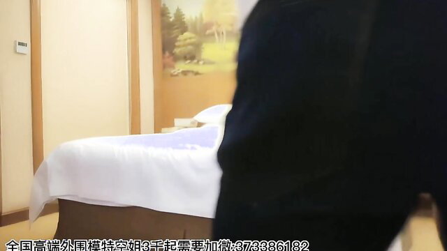 Asian beauty in black skirt bends over bed in hotel room