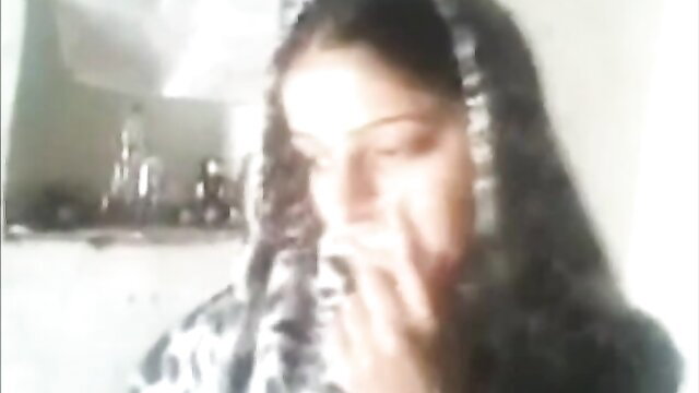 Veiled Pakistani wife in hijab smokes seductively, teasing desire