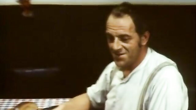 Vintage man in chef outfit at table in classic porn scene