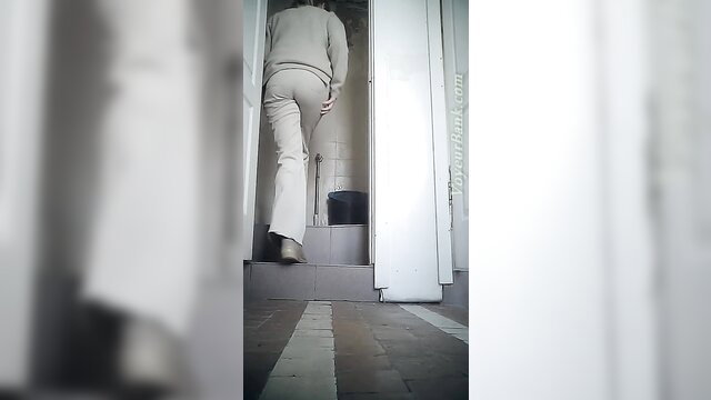 Hot office babe in tight white pants enters toilet to pee voyeur style