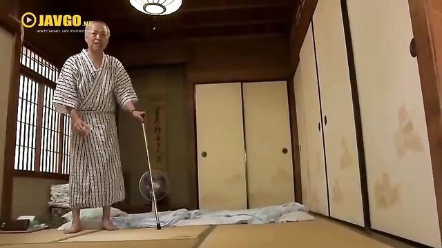 Elderly Japanese grandpa in kimono stands with cane in JAV family drama scene
