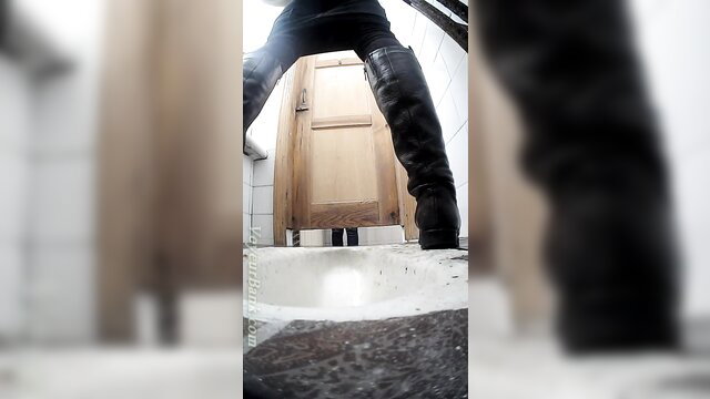 Pale teen in thigh-high boots stands over toilet in voyeur pee clip