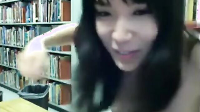 Naughty Asian teen fingers wet pussy in library